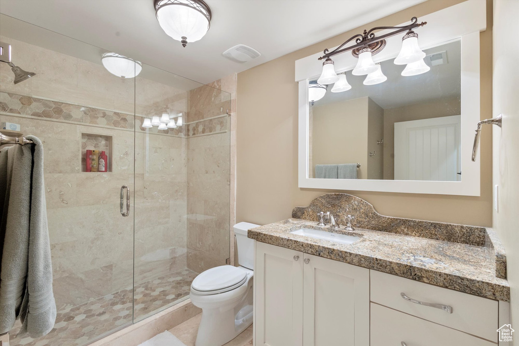 Bathroom with tile patterned floors, vanity, walk in shower, and toilet