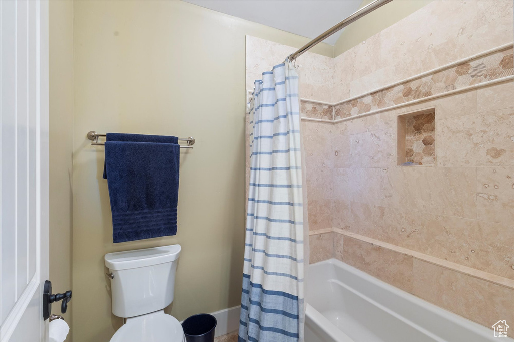 Bathroom featuring shower / bath combo and toilet