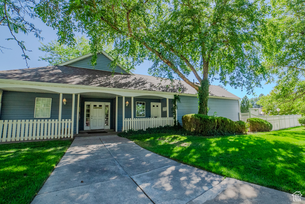 View of front of home featuring a front yard and covered porch