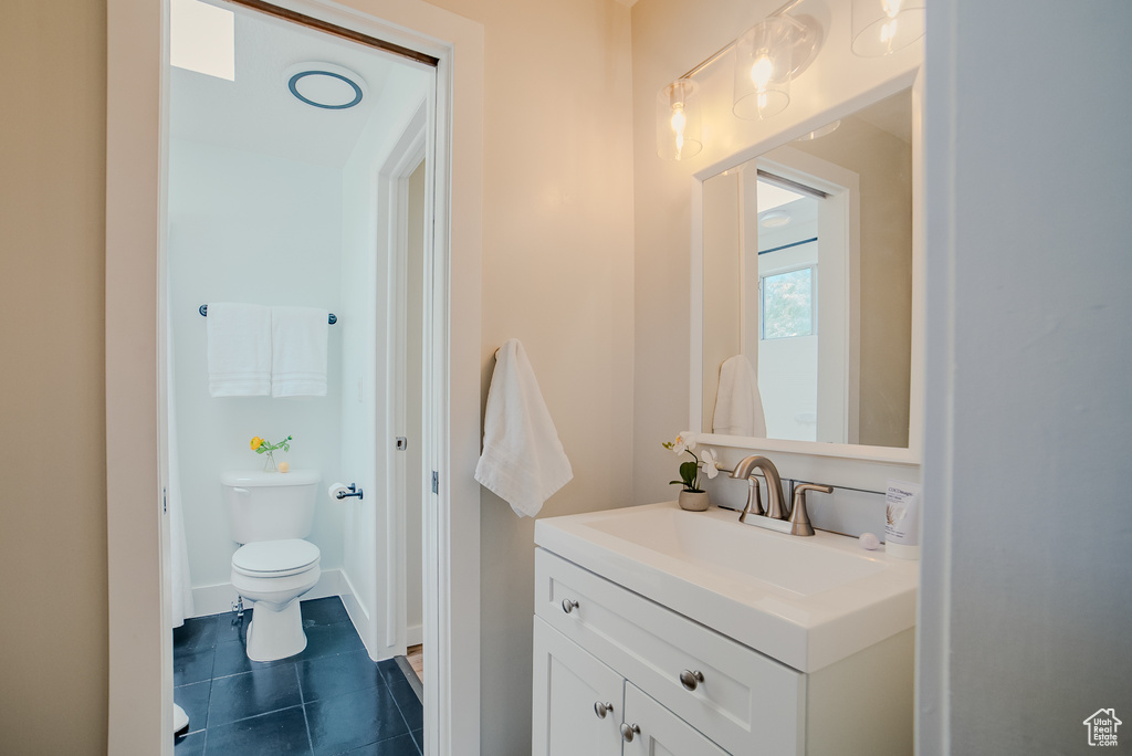 Bathroom featuring tile patterned flooring, vanity, and toilet