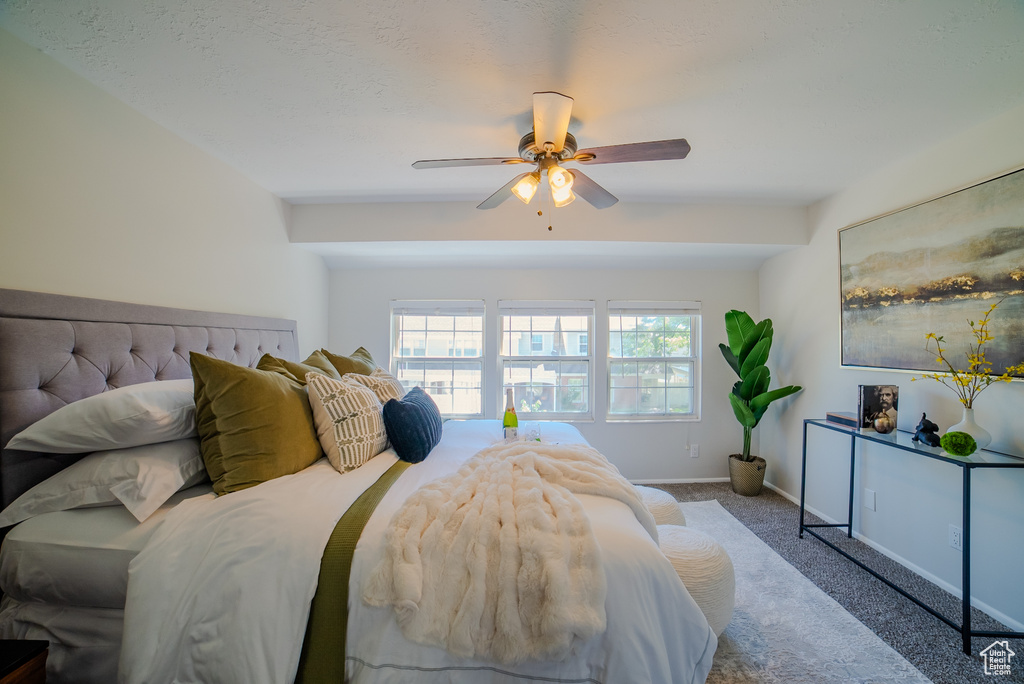 Carpeted bedroom featuring ceiling fan