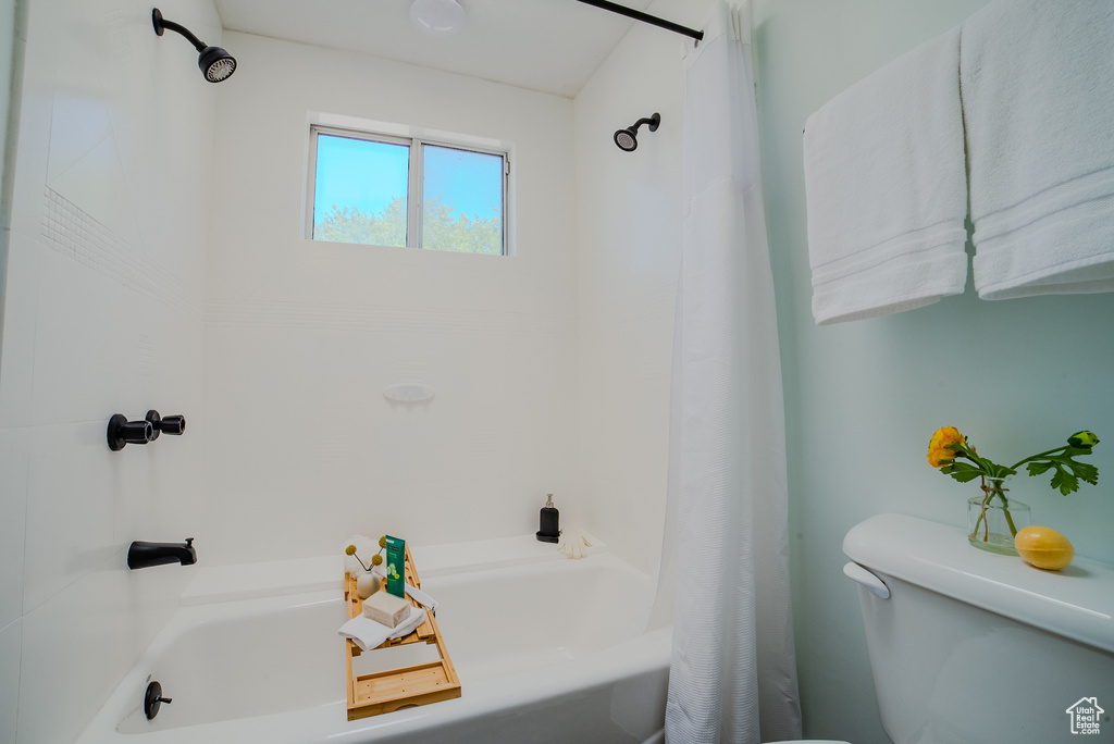 Bathroom with shower / bath combination with curtain and toilet