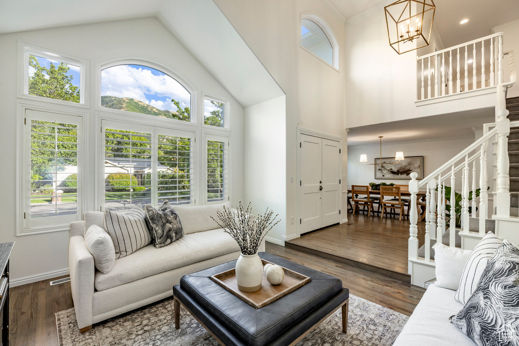 Living room featuring high vaulted ceiling, dark wood-type flooring, and a notable chandelier