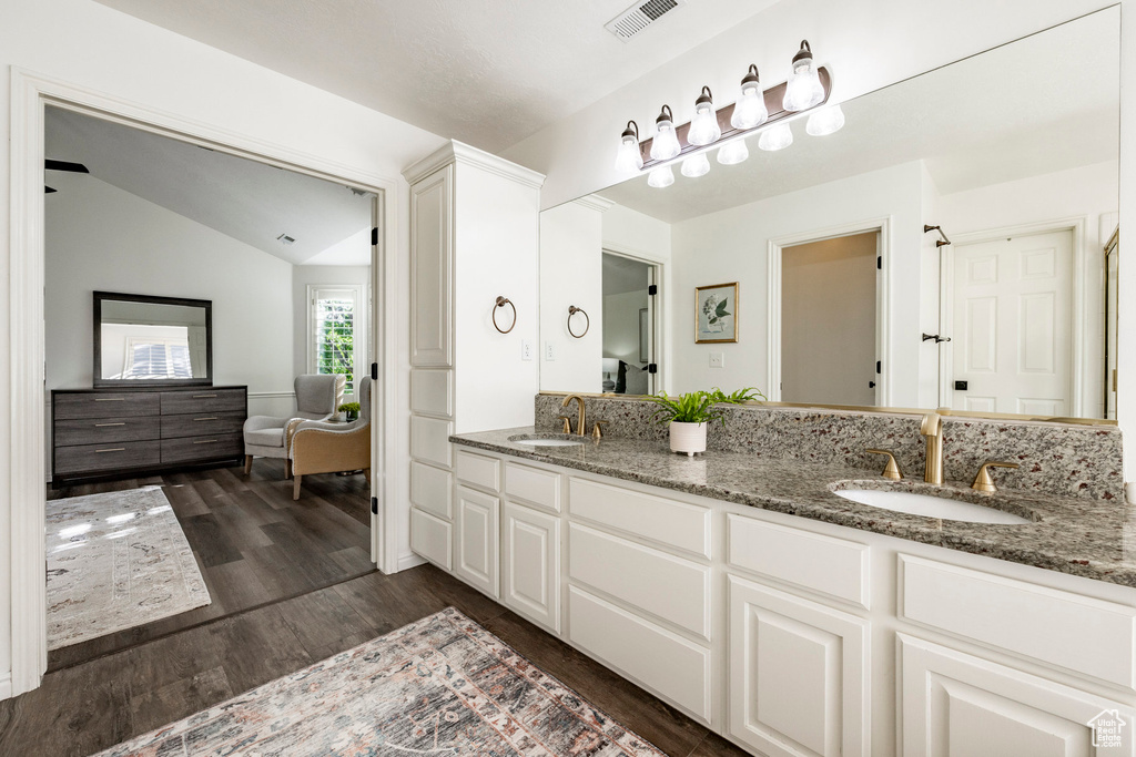 Bathroom featuring vaulted ceiling, vanity, and hardwood / wood-style floors