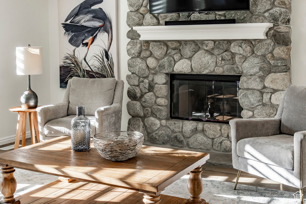 Sitting room featuring hardwood / wood-style flooring and a stone fireplace