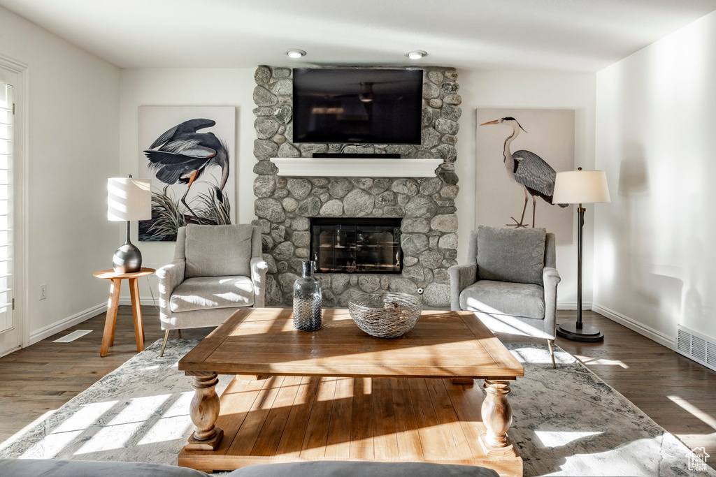 Living room featuring hardwood / wood-style flooring and a stone fireplace