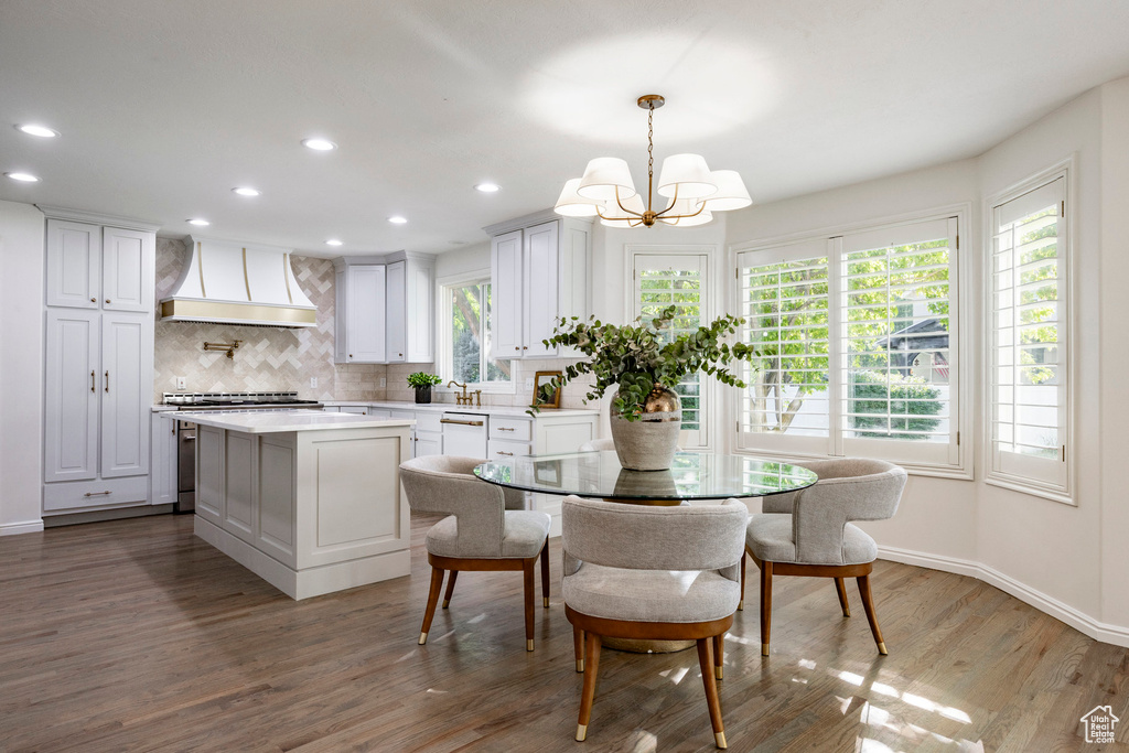 Dining room with hardwood / wood-style flooring, plenty of natural light, and a chandelier