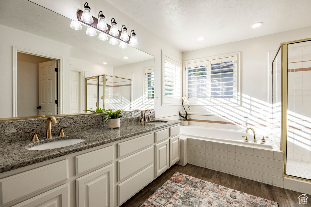 Bathroom with shower with separate bathtub, wood-type flooring, and vanity