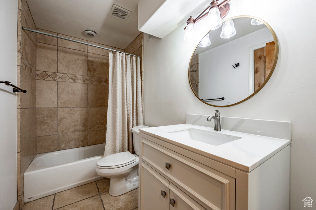 Full bathroom with shower / bath combination with curtain, tile patterned floors, toilet, and vanity