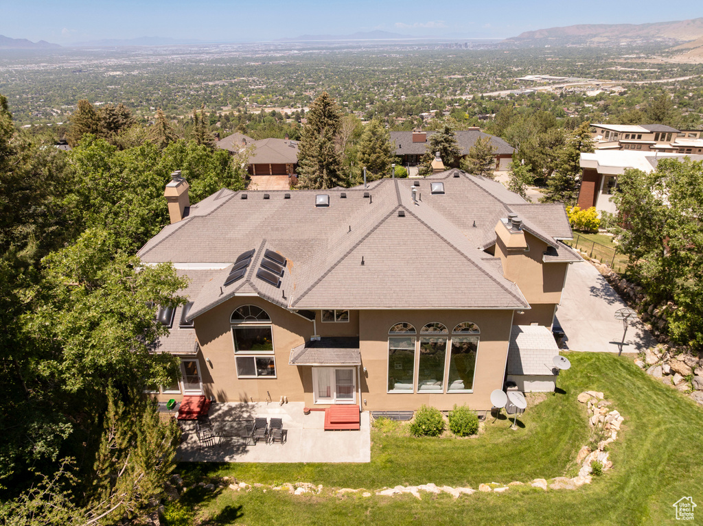 Aerial view of property and surrounding area featuring a mountain backdrop