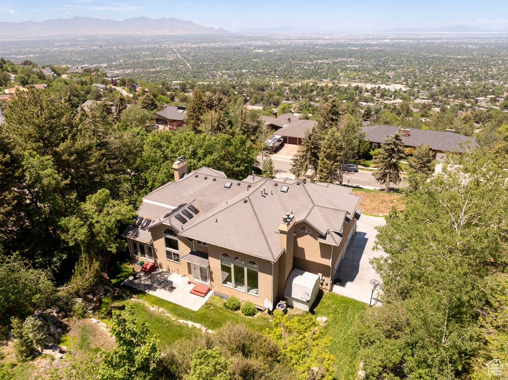 Aerial view of property and surrounding area with a mountain backdrop