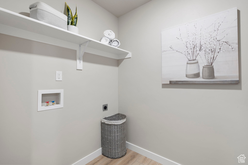 Laundry area featuring light wood-type flooring, washer hookup, and electric dryer hookup