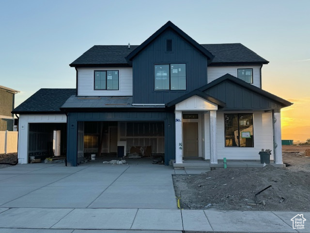 View of front of house featuring a porch and a garage