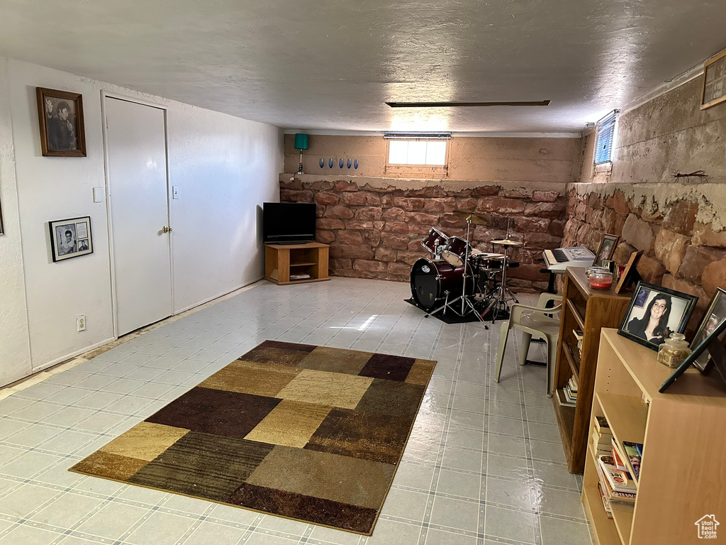 Basement featuring a textured ceiling and light tile patterned flooring