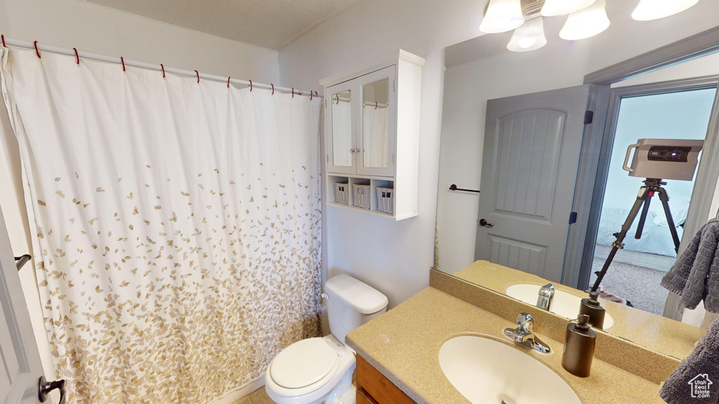 Bathroom with a shower with curtain, vanity, and toilet