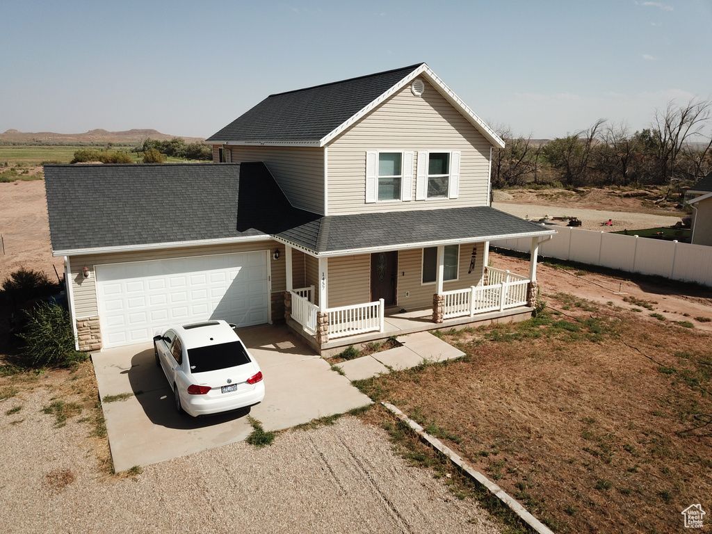 View of front facade featuring covered porch and a garage