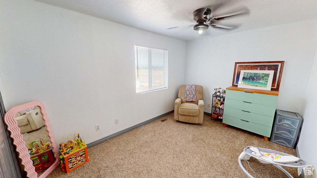 Living area featuring ceiling fan and light carpet