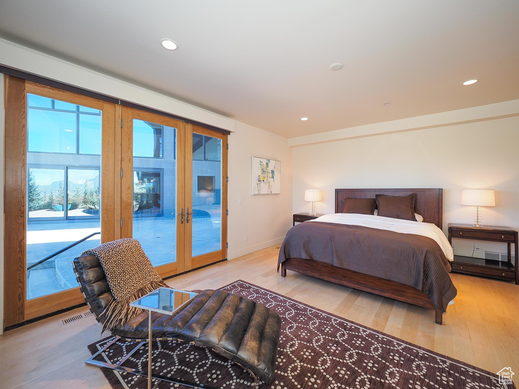 Bedroom featuring access to outside, light hardwood / wood-style flooring, and french doors