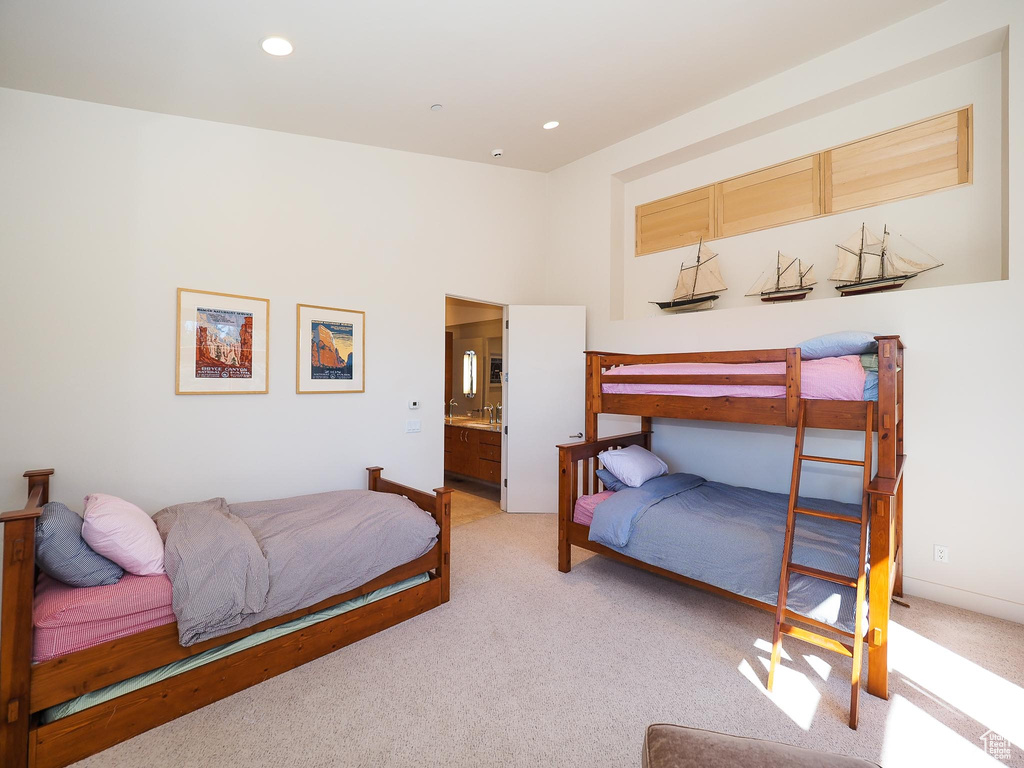 Bedroom with light colored carpet and ensuite bathroom