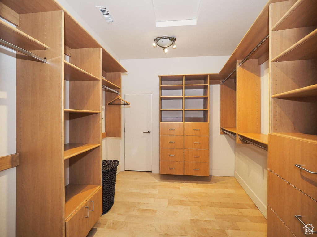 Walk in closet with light wood-type flooring