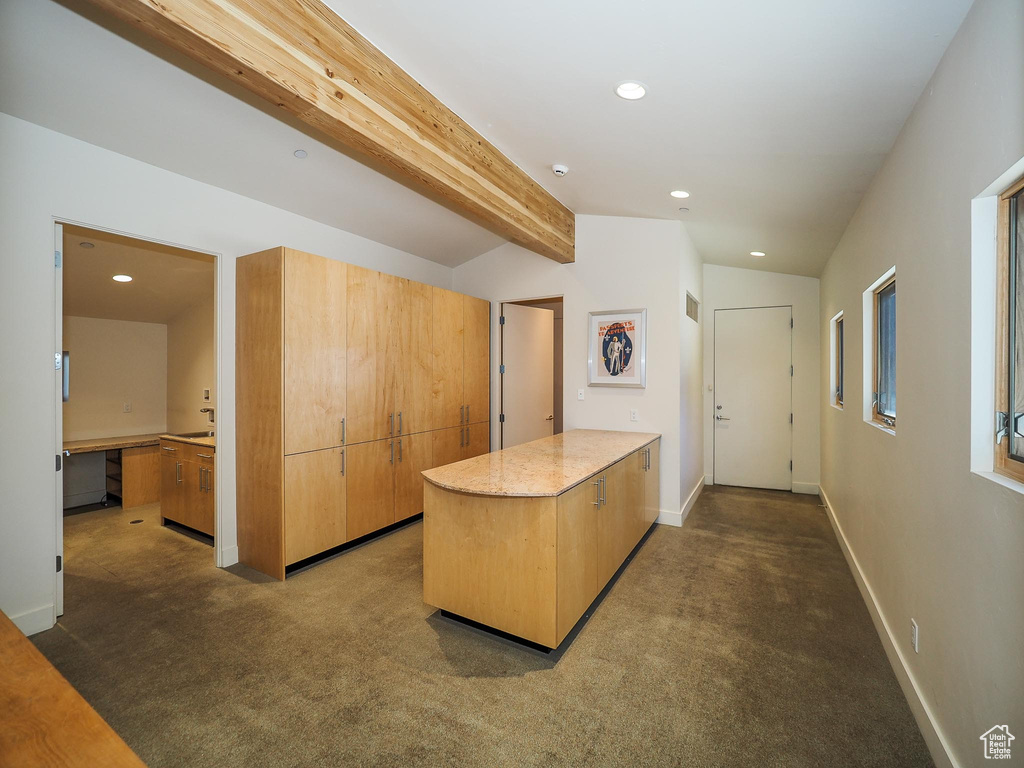 Interior space with lofted ceiling with beams and carpet