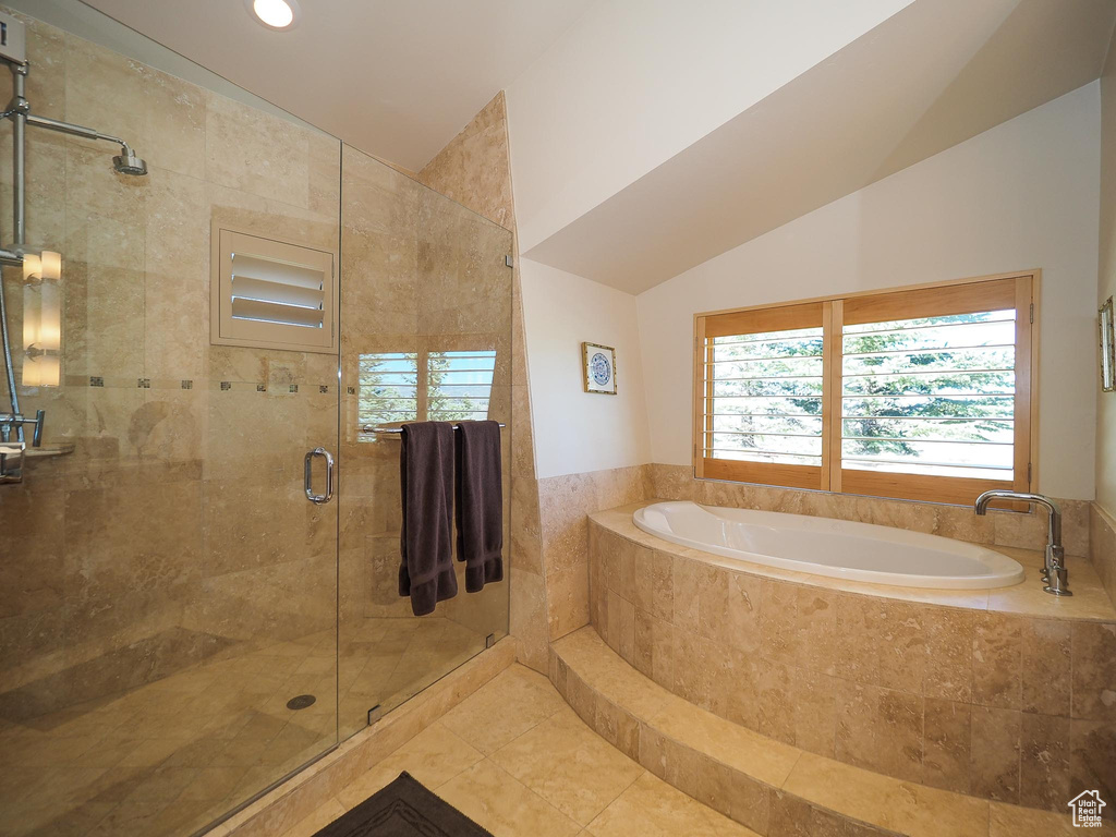 Bathroom with vaulted ceiling, tile patterned flooring, and separate shower and tub