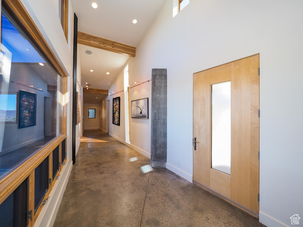 Hall featuring beam ceiling and high vaulted ceiling