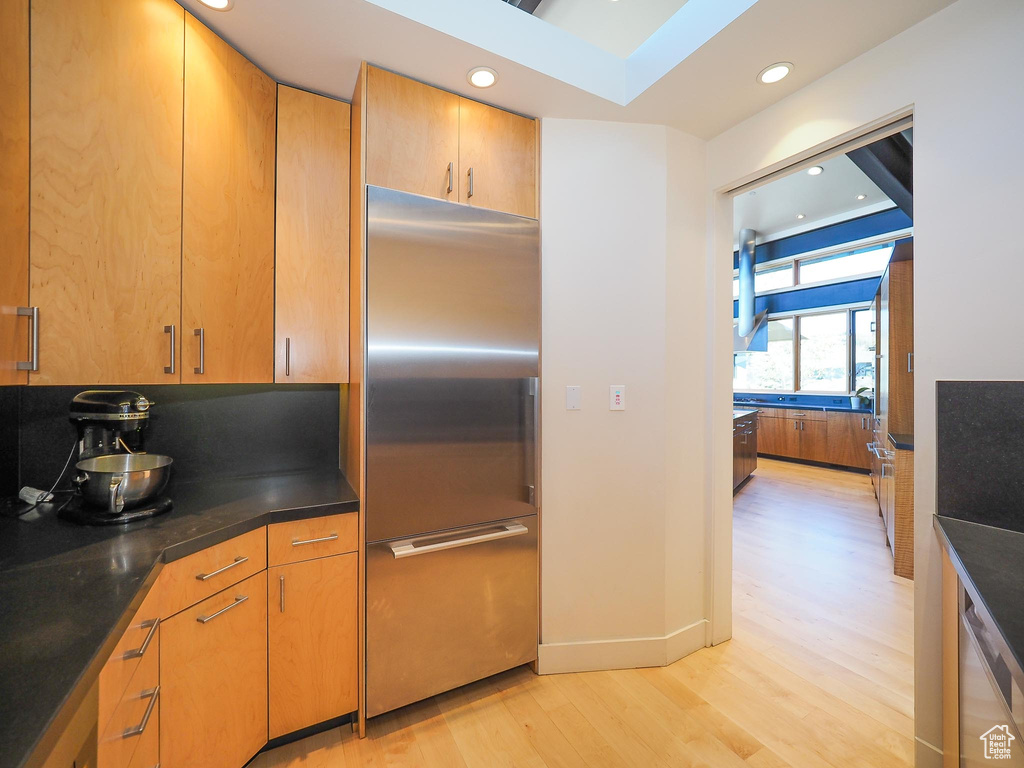 Kitchen with light hardwood / wood-style flooring and built in fridge