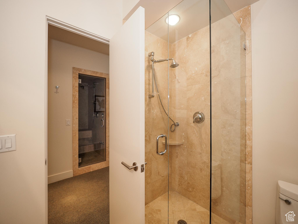 Bathroom featuring an enclosed shower and toilet