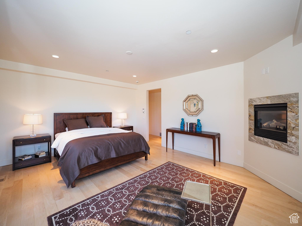 Bedroom with light wood-type flooring and a fireplace