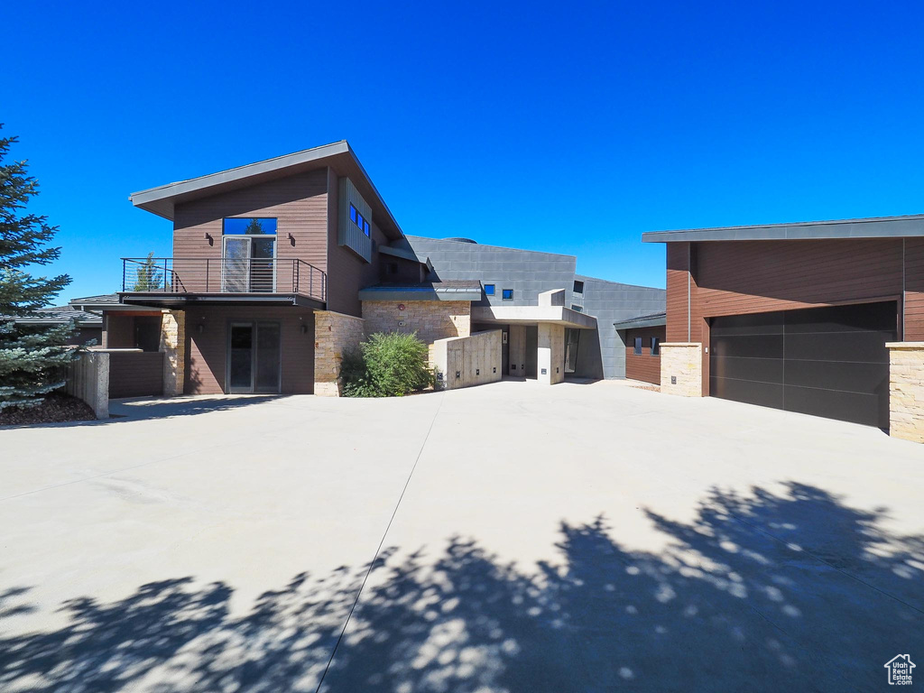 View of property exterior with a balcony and a garage