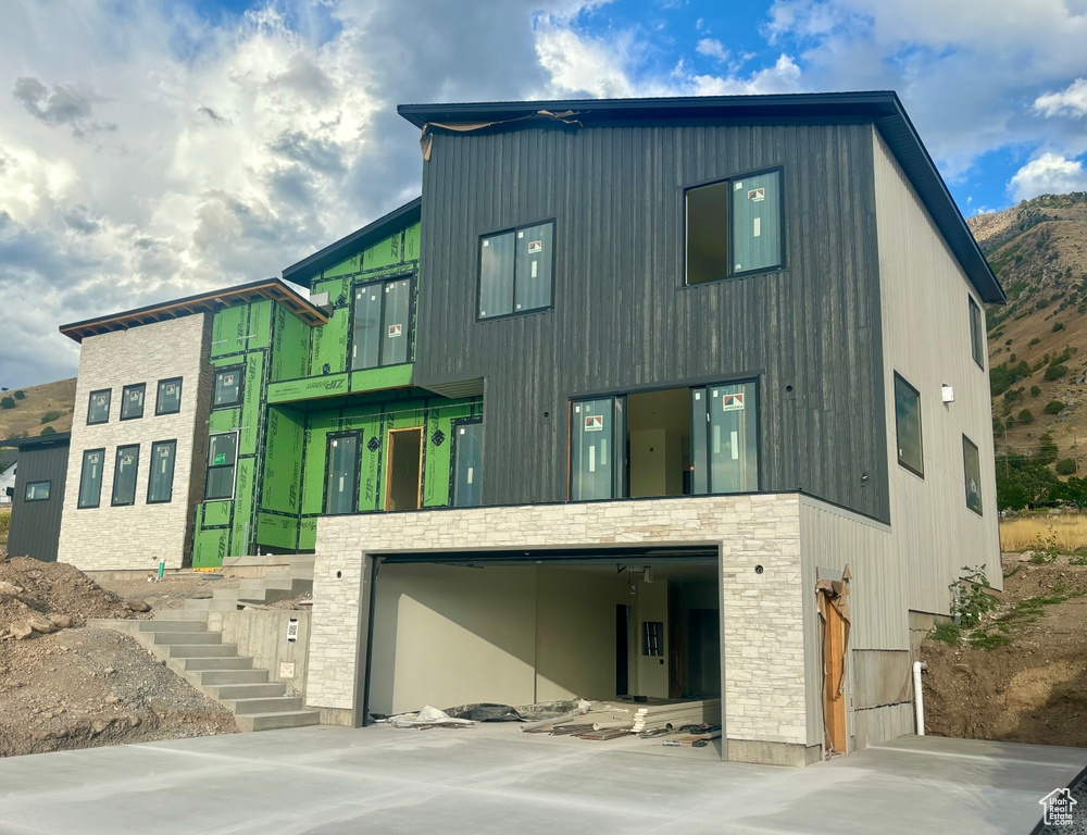 View of front facade featuring a garage and a mountain view