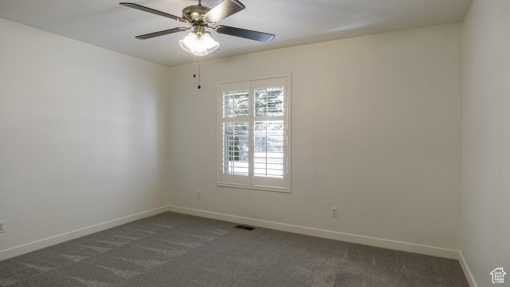 Carpeted spare room with ceiling fan