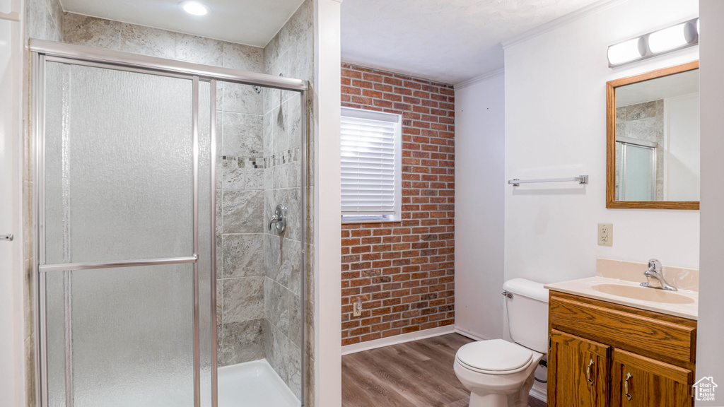 Bathroom featuring hardwood / wood-style floors, toilet, and a shower with door