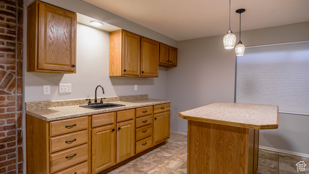 Kitchen with sink, a center island, pendant lighting, and light tile patterned floors