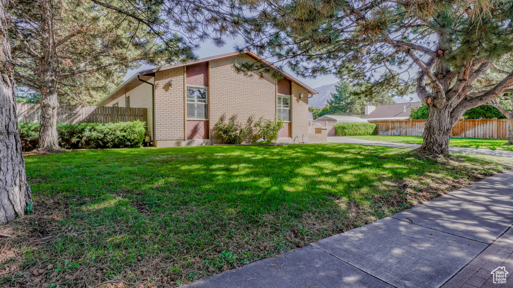 View of side of property with a lawn