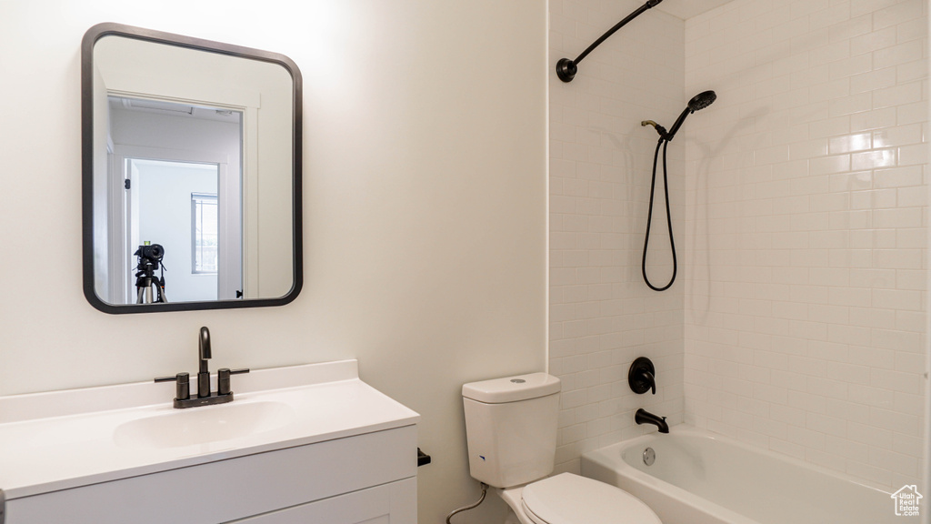 Full bathroom featuring tiled shower / bath, toilet, and vanity