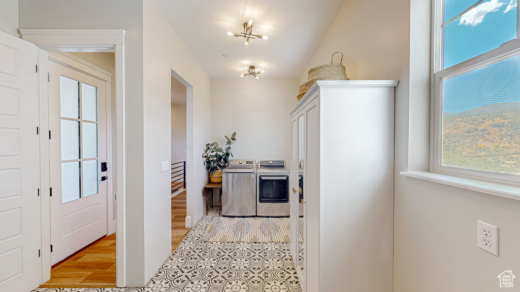 Hall featuring a wealth of natural light, washing machine and dryer, and light hardwood / wood-style floors