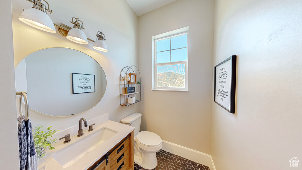 Bathroom with toilet, tile patterned flooring, and vanity