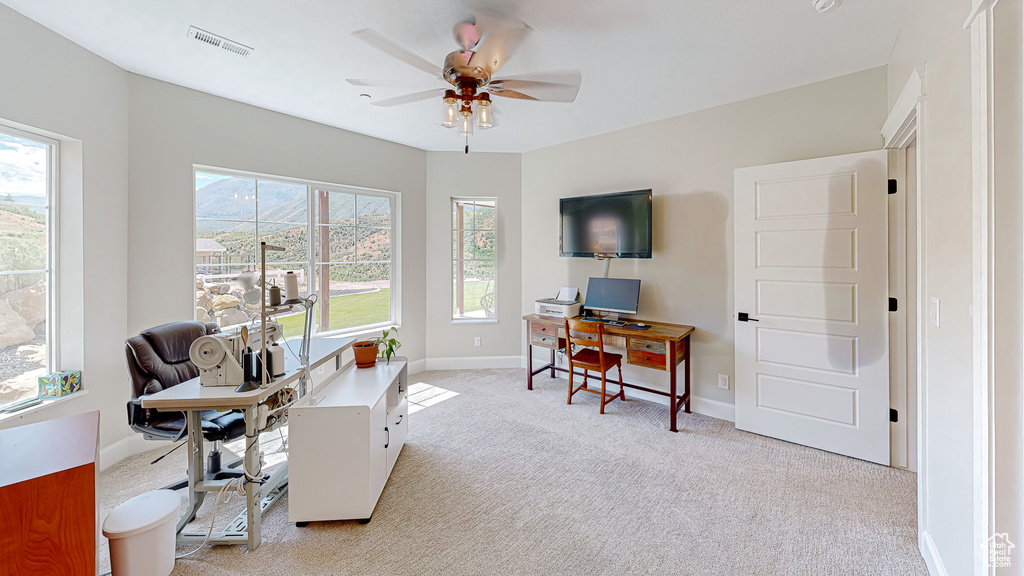 Office with ceiling fan and light carpet