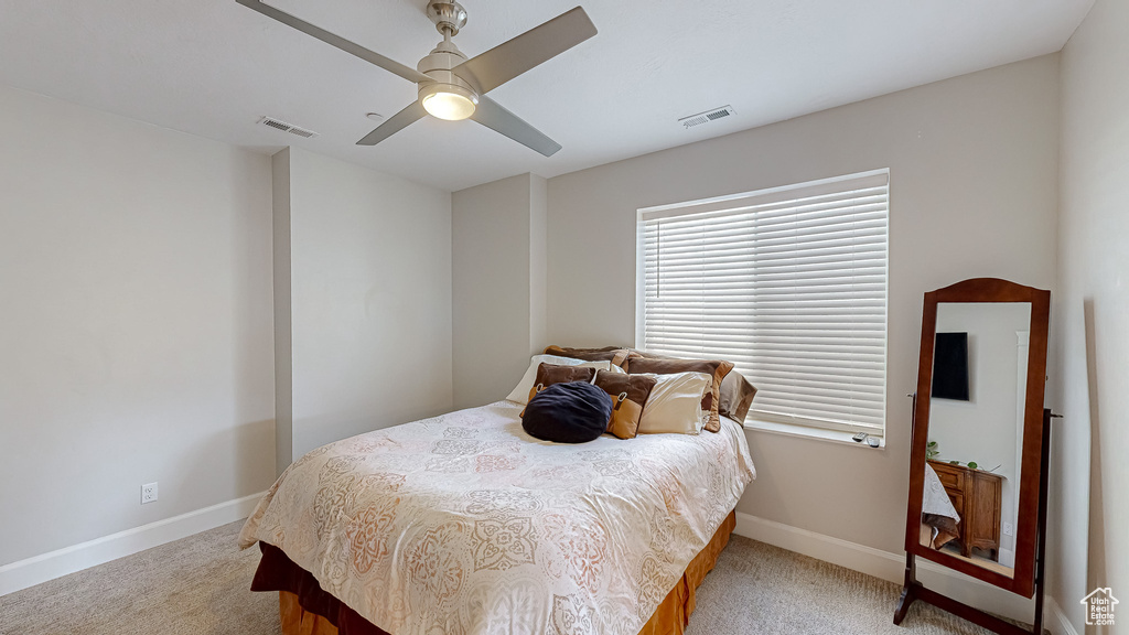 Bedroom with ceiling fan and light colored carpet