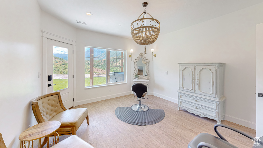 Sitting room featuring light hardwood / wood-style floors and a notable chandelier