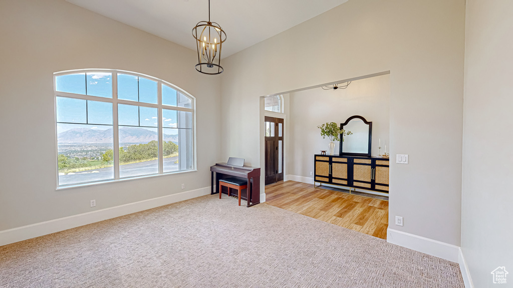 Interior space featuring vaulted ceiling, an inviting chandelier, and light hardwood / wood-style floors