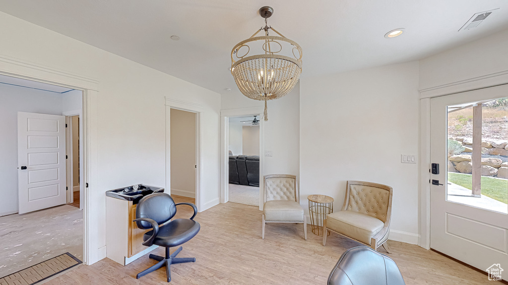 Sitting room featuring light wood-type flooring and a chandelier