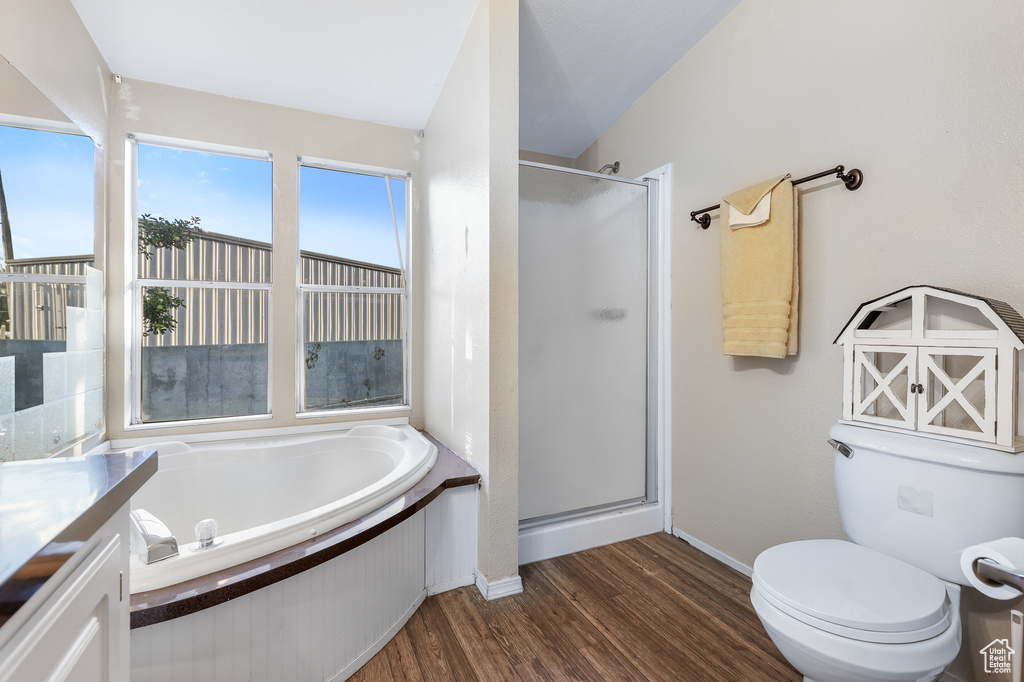 Full bathroom with independent shower and bath, toilet, vanity, wood-type flooring, and lofted ceiling