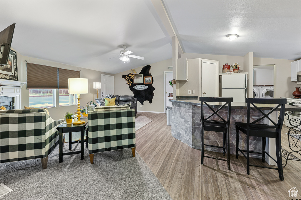 Interior space featuring ceiling fan, white cabinetry, independent washer and dryer, light hardwood / wood-style floors, and white fridge