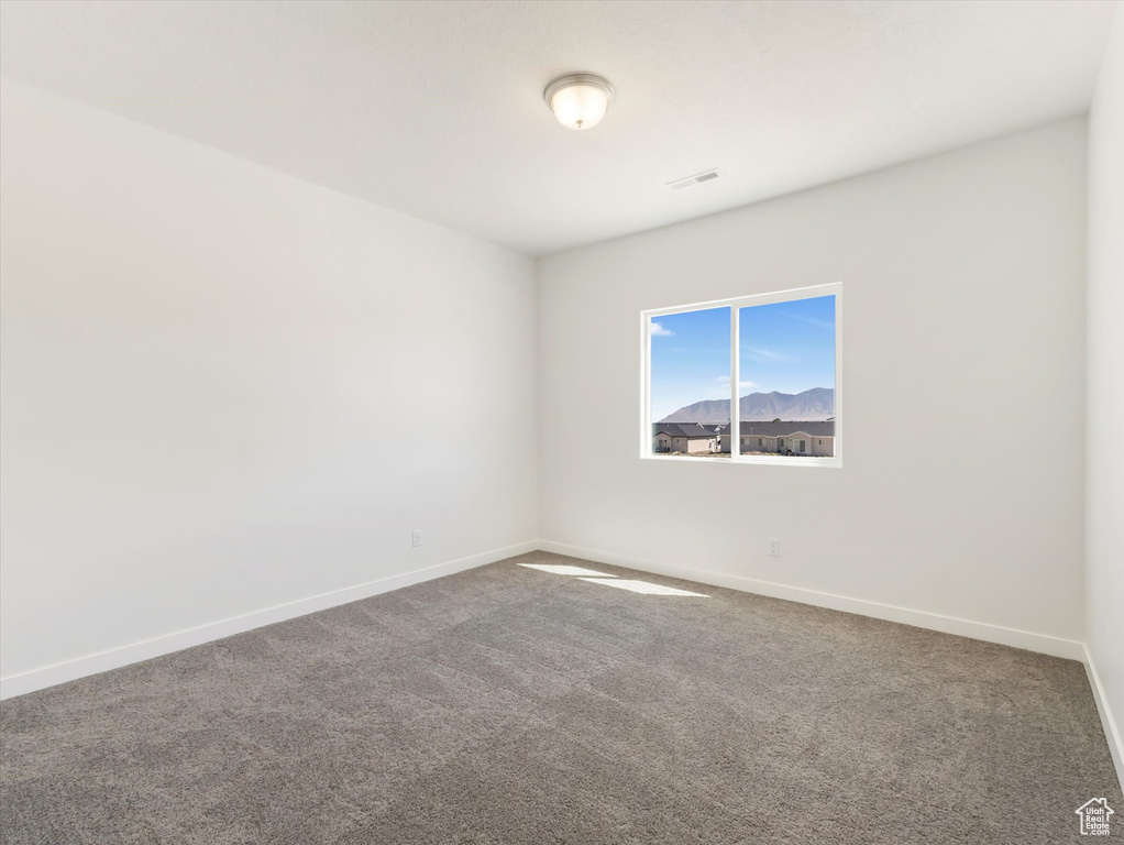 Carpeted empty room featuring a mountain view