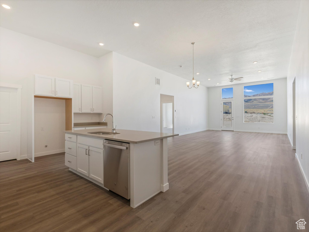 Kitchen featuring stainless steel dishwasher, a kitchen island with sink, white cabinetry, hardwood / wood-style flooring, and sink