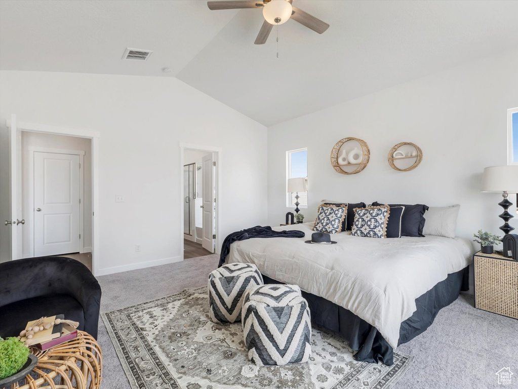 Carpeted bedroom with ceiling fan and vaulted ceiling