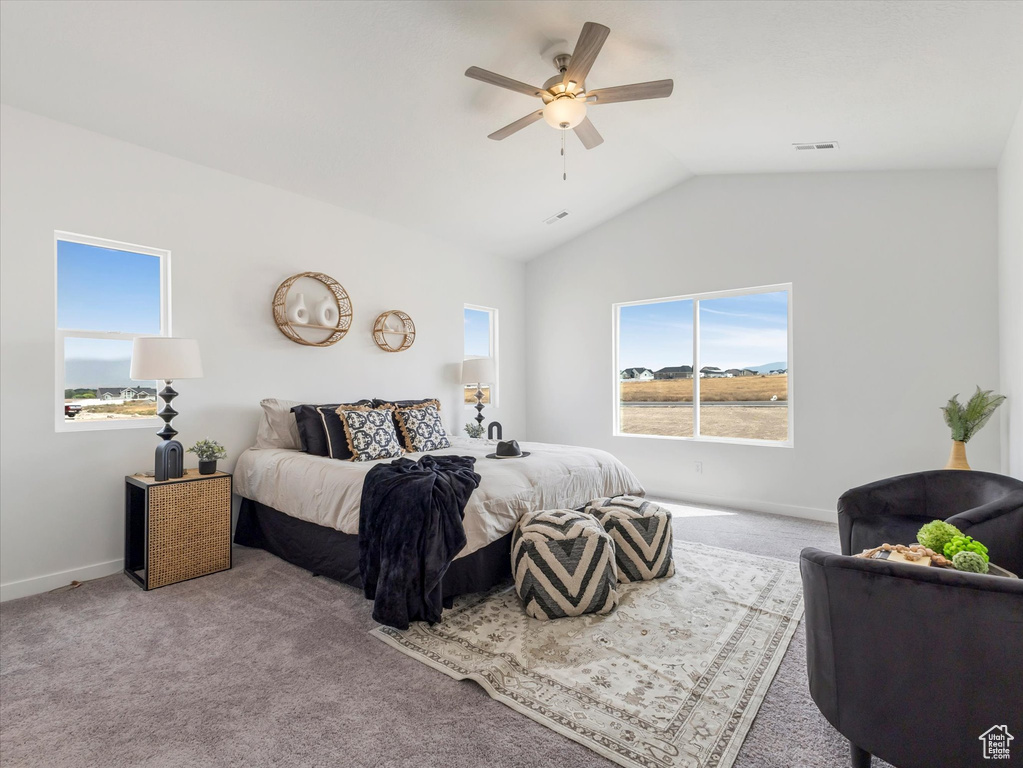 Carpeted bedroom with ceiling fan and lofted ceiling